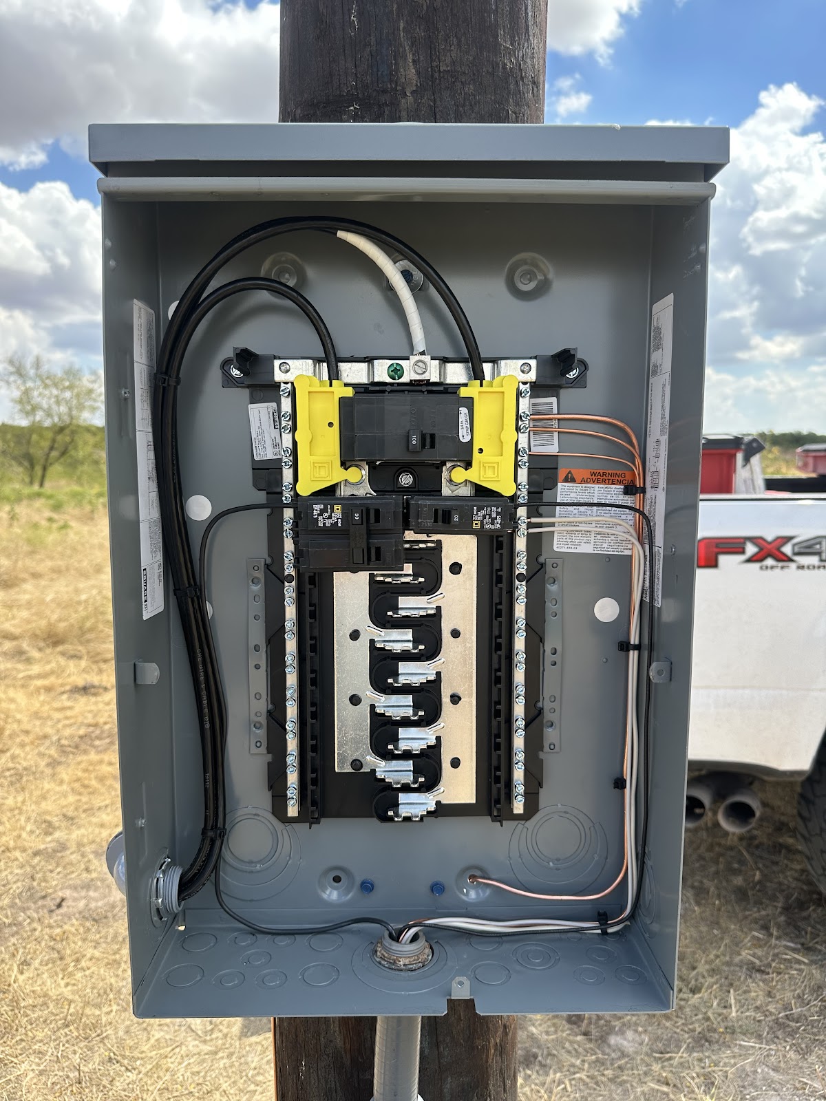 A new breaker panel wired and installed clean on a service pole by Coy Electric